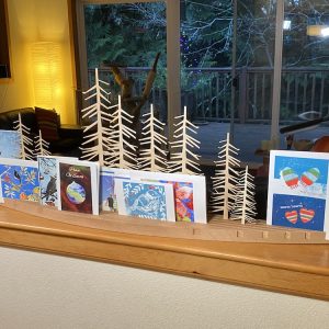 Holiday card holder displayed with cards and laser cut tree silhouettes